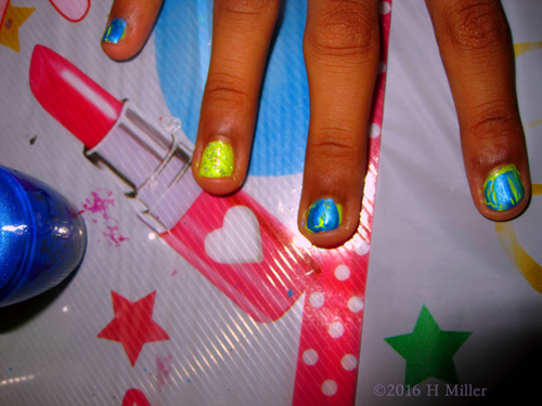 A Pretty Girls Manicure With Glittery Yellow Accent Nail.