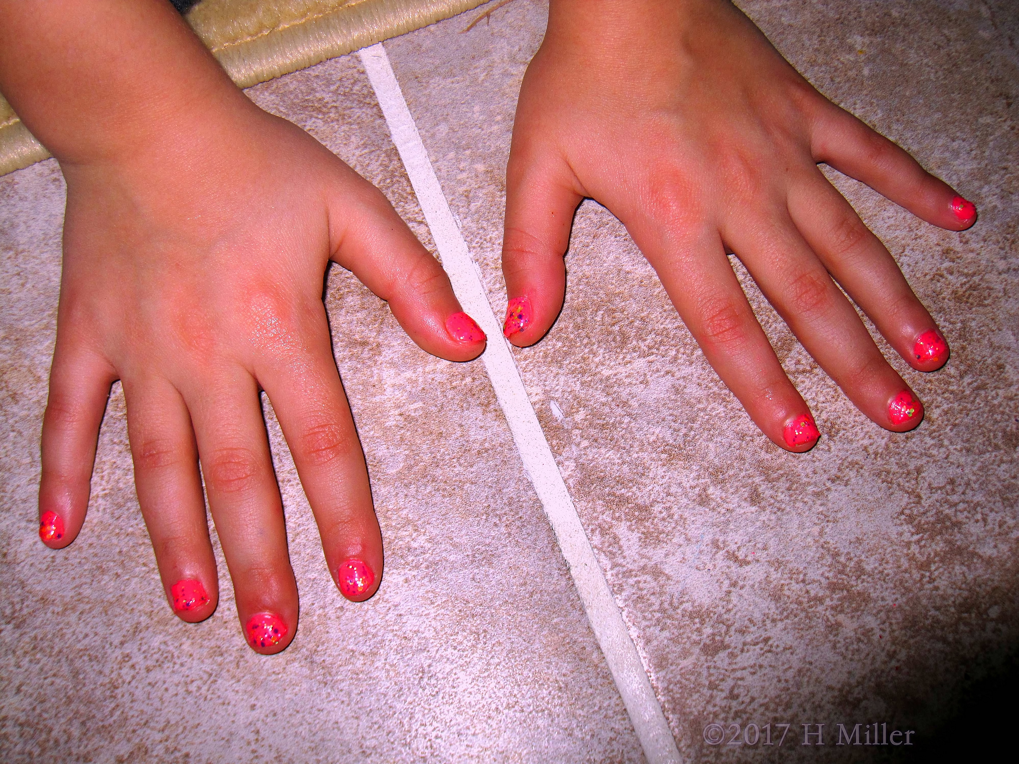 A Closeup Of Her Pink And Glitter Kids Mani. 