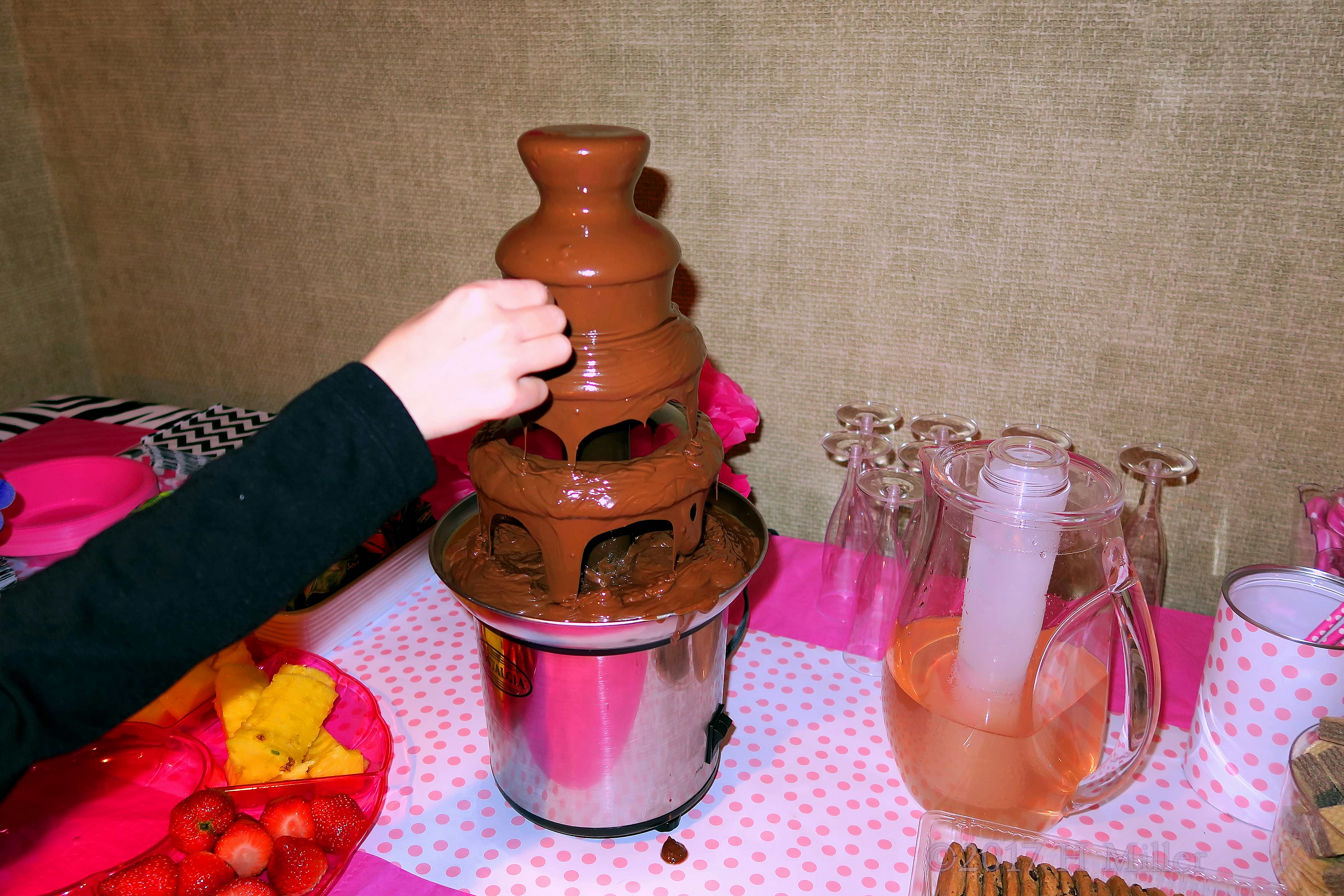 Dipping Fruit Into The Chocolate Fondue Fountain. Dipping Fruit Into The Chocolate Fondue Fountain.