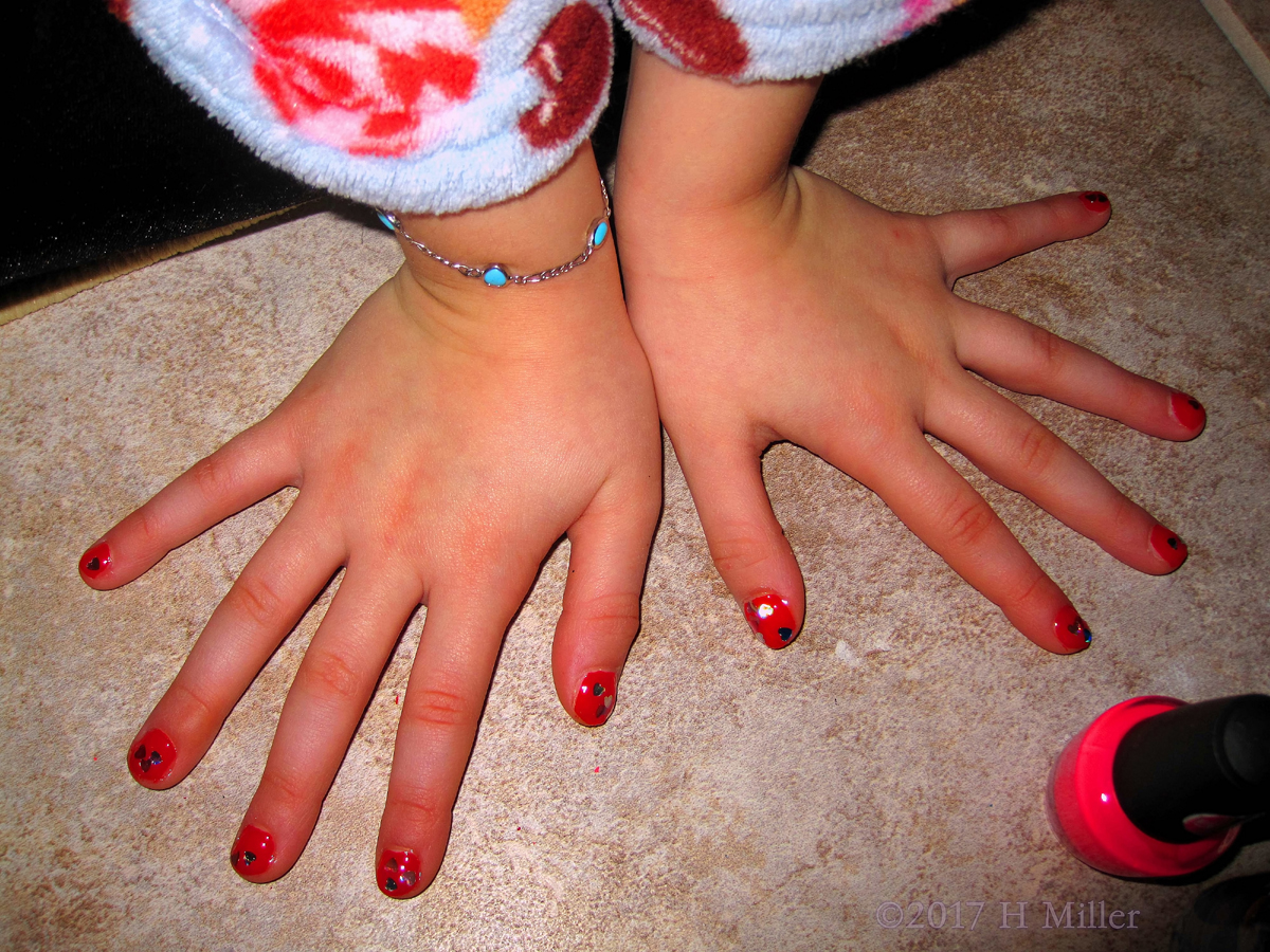 Red Nail Polish With Heart Glitter For This Girl's Mini Manicure.