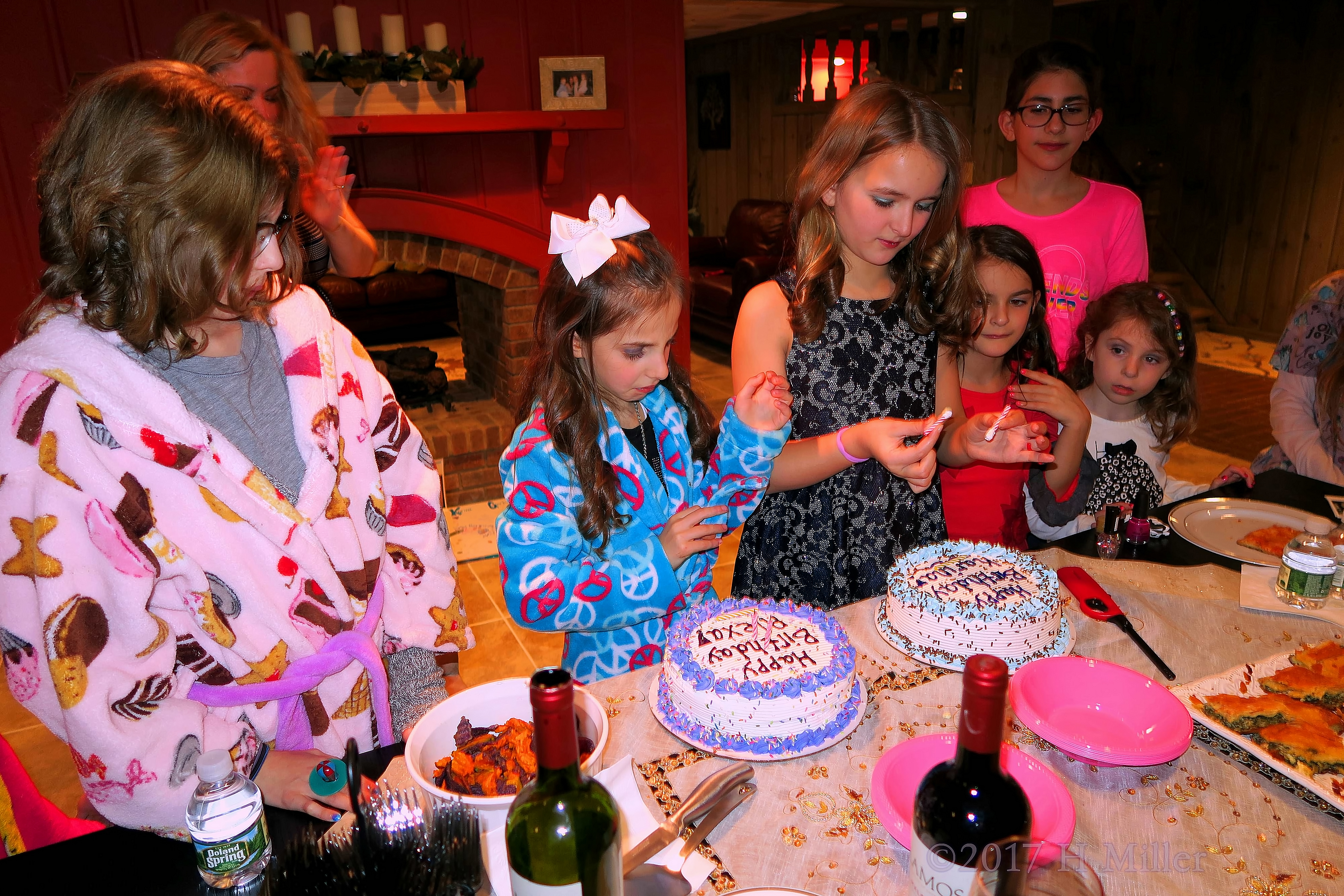 Taking Out The Candles On Their Birthday Cakes. 