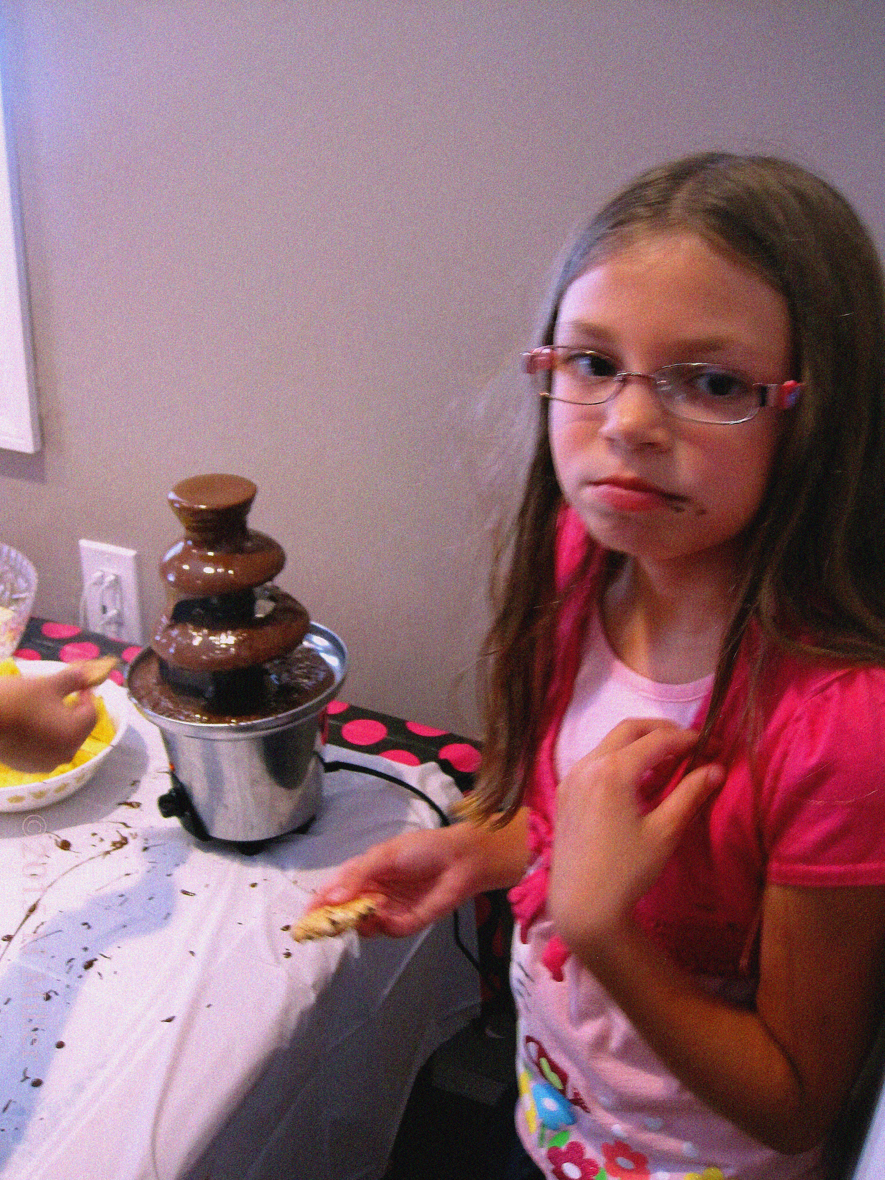 The Birthday Girl Eating Cookies Dipped In The Chocolate Fountain. The Birthday Girl Eating Cookies Dipped In The Chocolate Fountain.