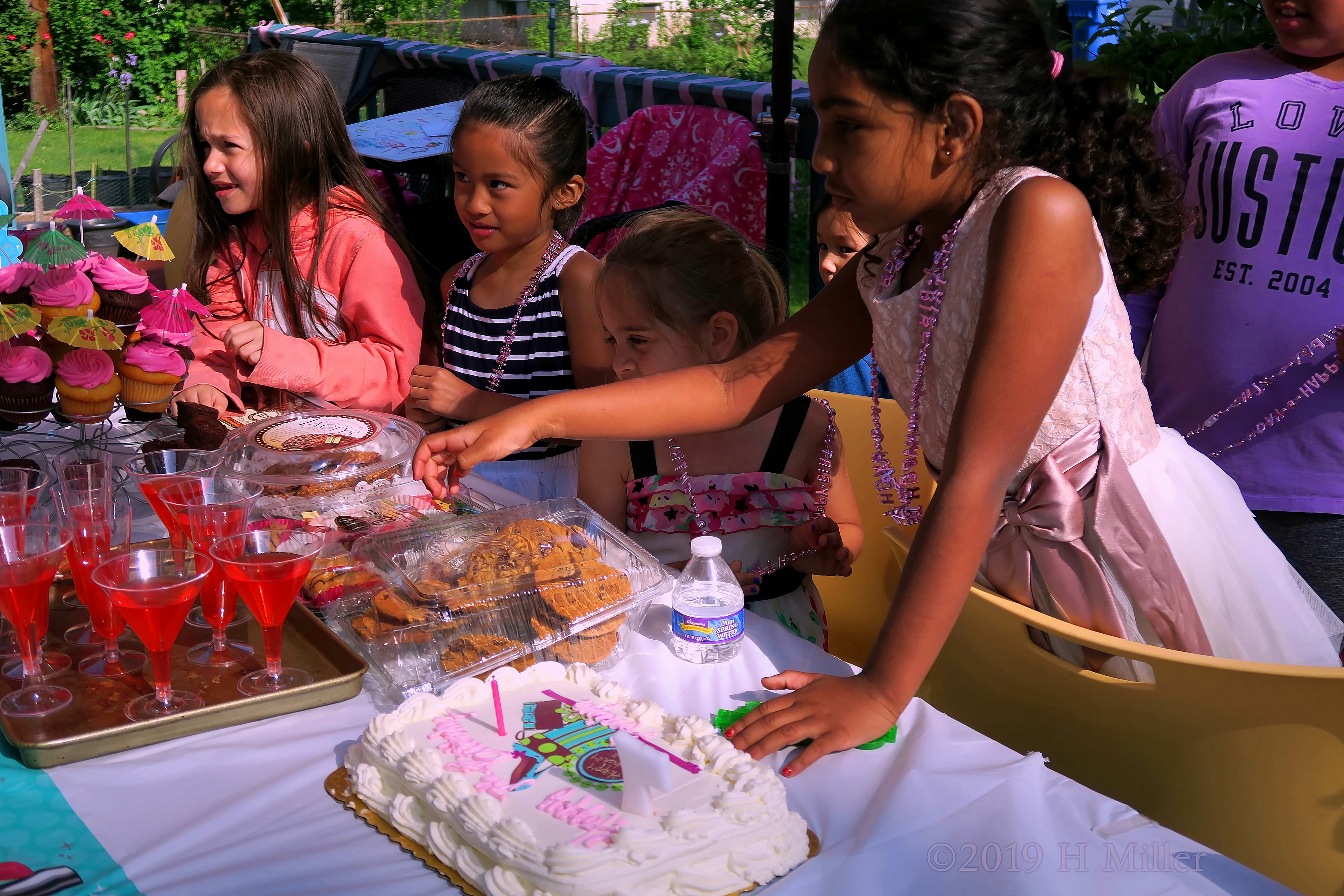The Birthday Girl And Friends Enjoy Snacks From The Table The Birthday Girl And Friends Enjoy Snacks From The Table