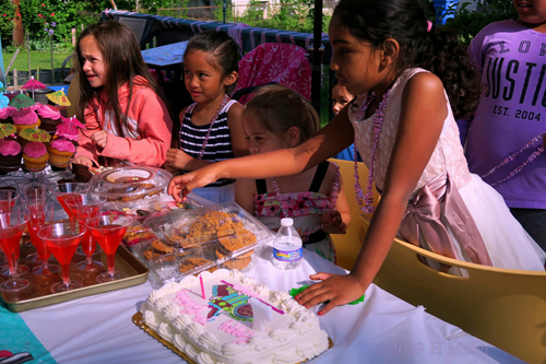 The Birthday Girl And Friends Enjoy Snacks From The Table The Birthday Girl And Friends Enjoy Snacks From The Table