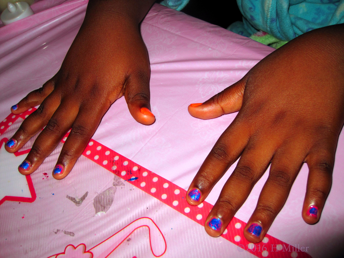 Blue Shatter And Orange Girls Manicure On Pink Tablecloth 