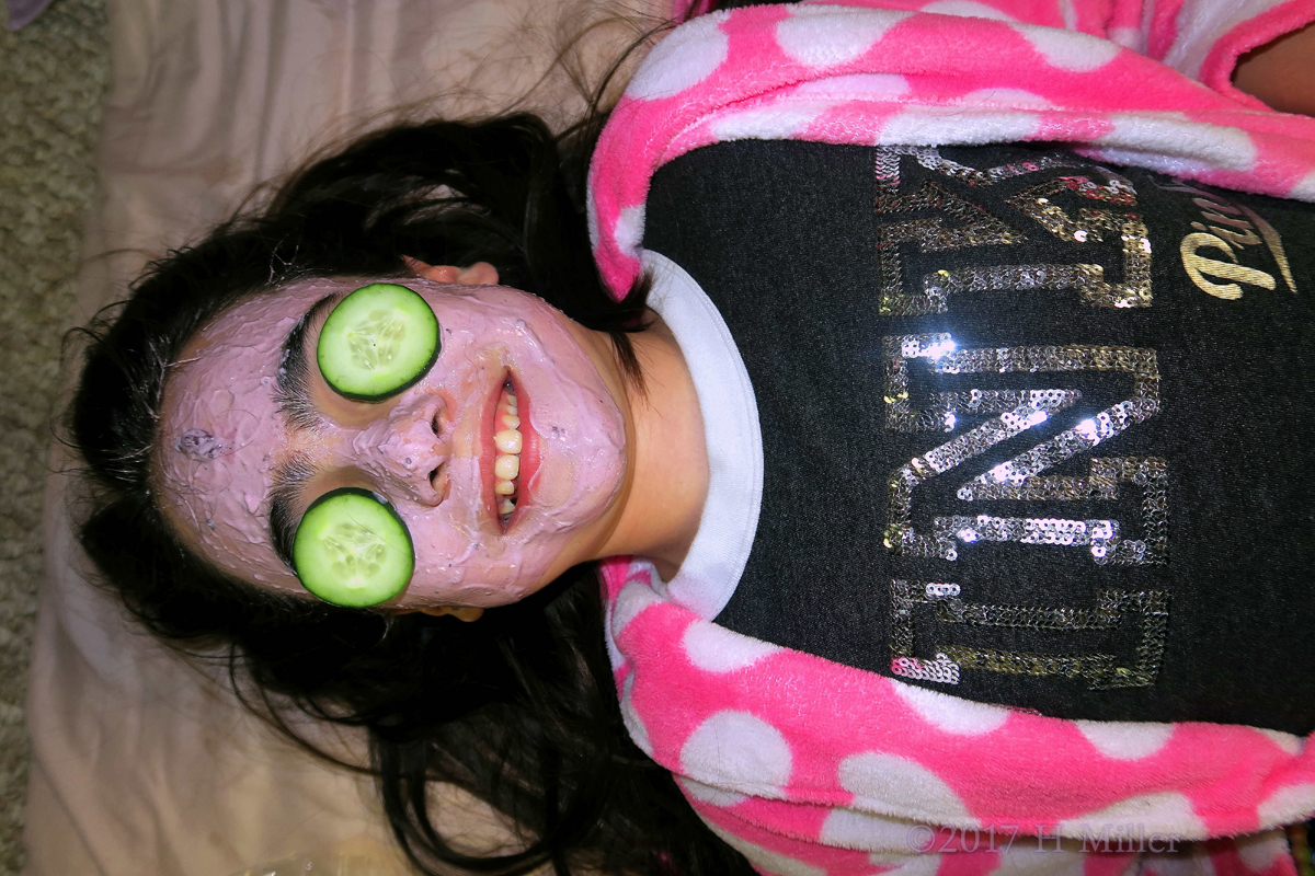 Smiling During Kids Facials With Blueberry Masque And Cukes On Her Eyes. 