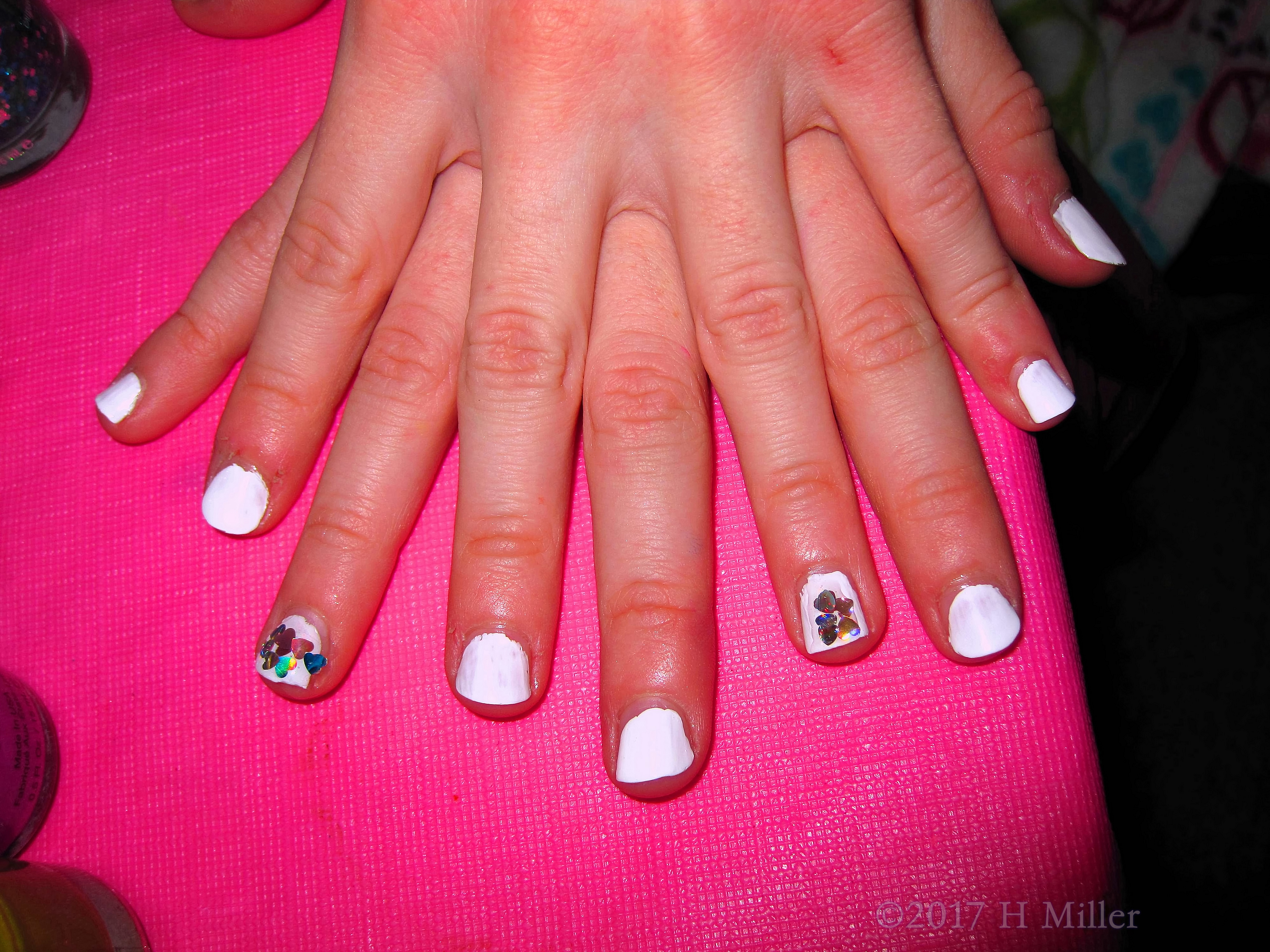 Girls Mini Mani Closeup With Hearts On White Polish. Girls Mini Mani Closeup With Hearts On White Polish.