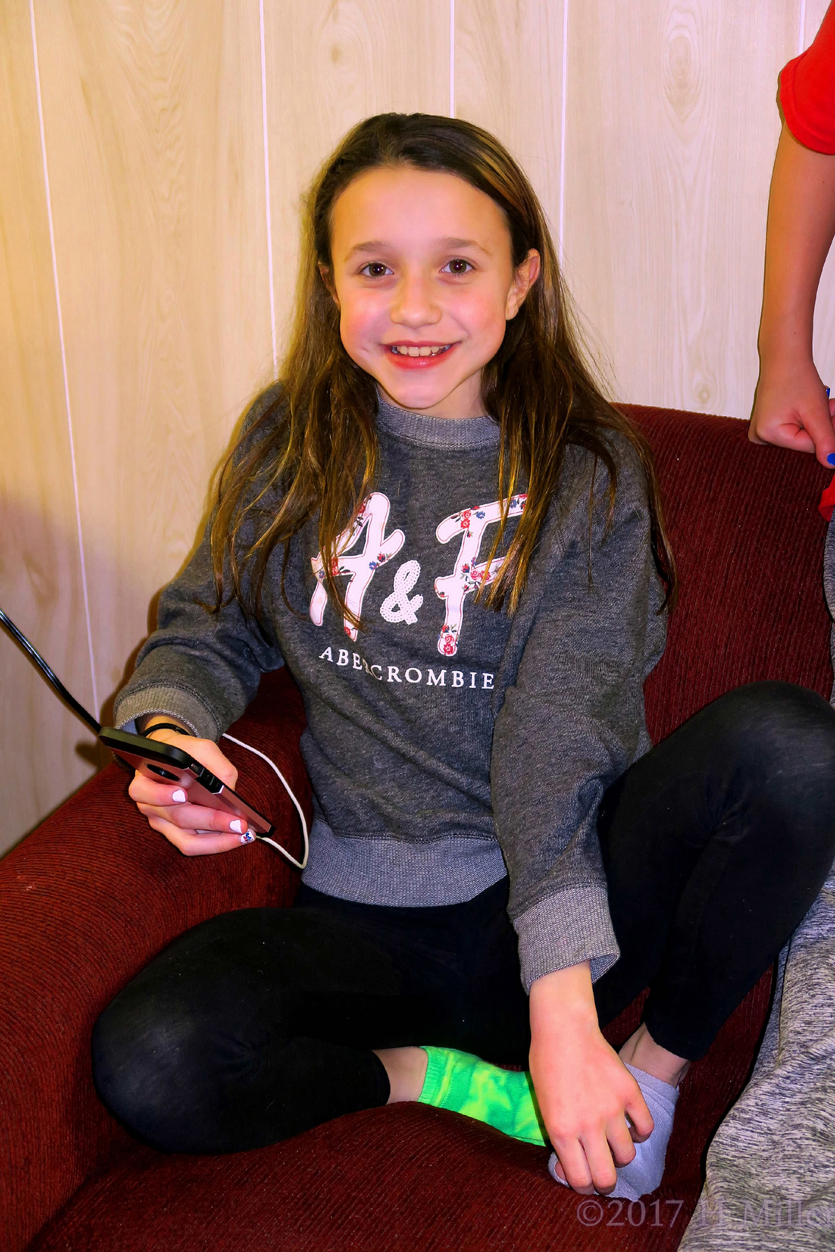 Hanging Out With Her Smartphone At The Kids Party. 