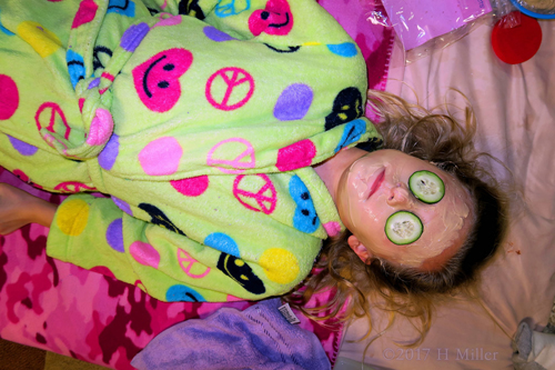Relaxing With Cukes On Her Eyes During Kids Facials. 
