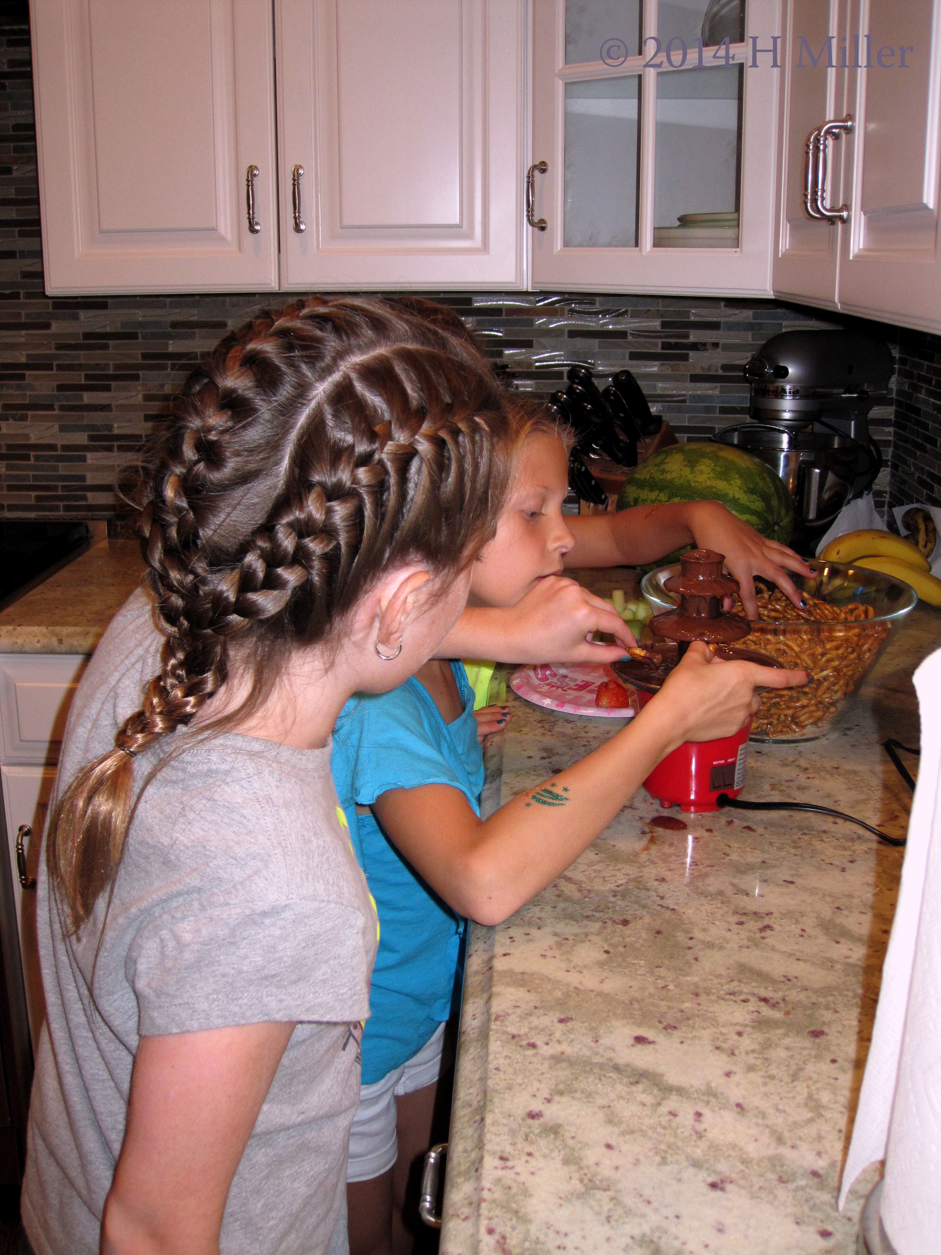 The Girls Dipping Pretzels Into The Chocolate. The Girls Dipping Pretzels Into The Chocolate.
