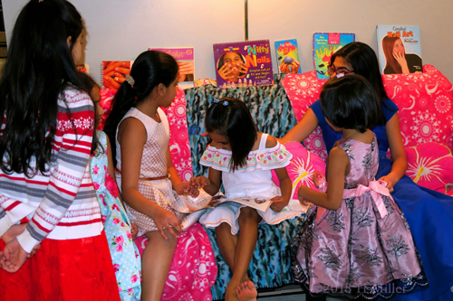 Wondering Which Hairstyle Would Go Best, She Flips Through The Book With Her Friends.