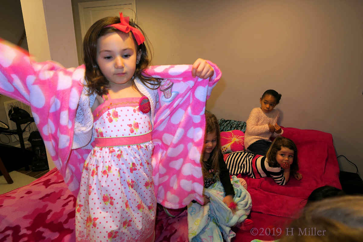 Party Guest Putting On Her Kids Spa Robe 
