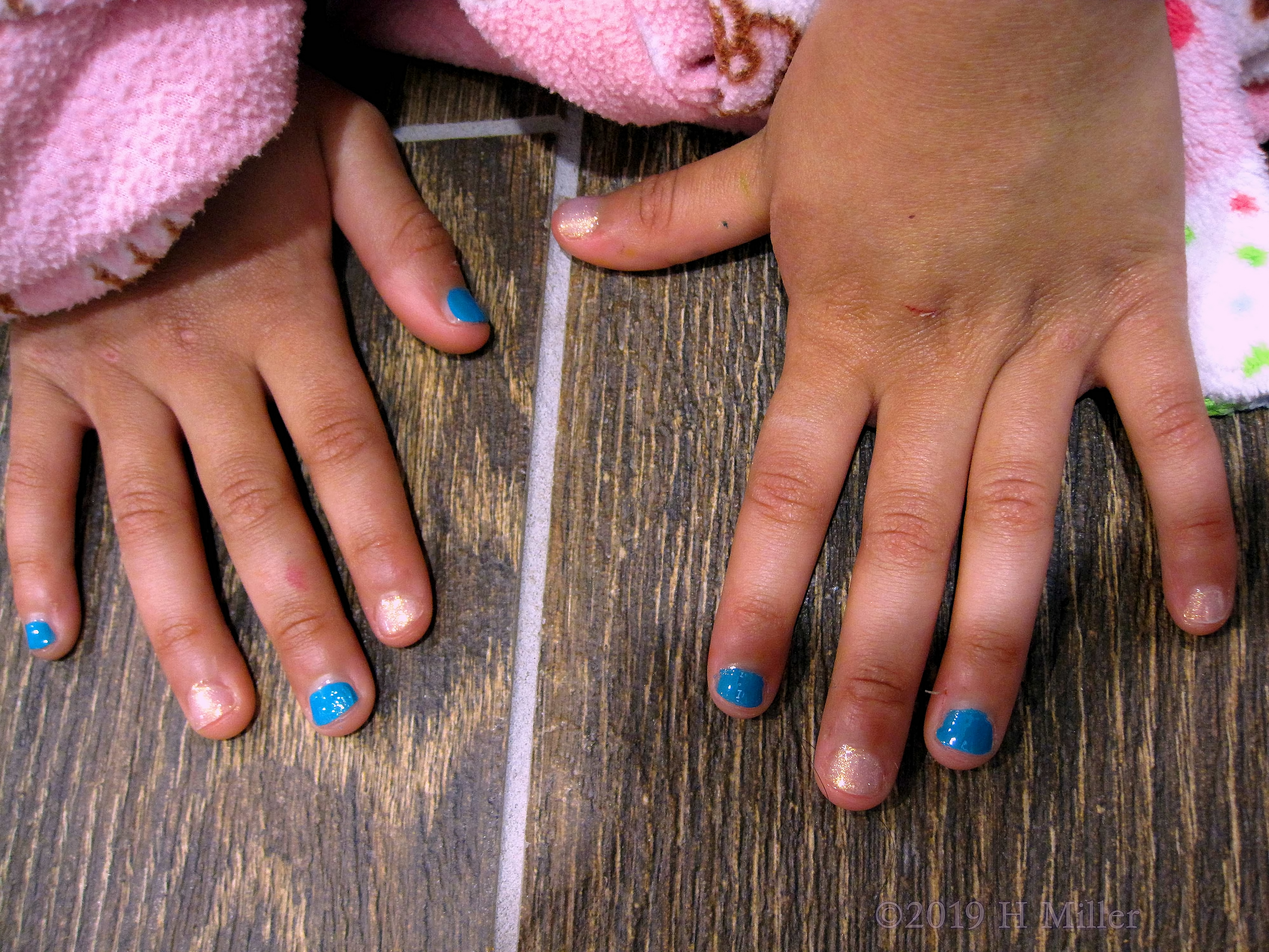 Kids Manicure Has Light Pink Glitter Polish With Blue Glossy Polish On Alternating Fingers Kids Manicure Has Light Pink Glitter Polish With Blue Glossy Polish On Alternating Fingers
