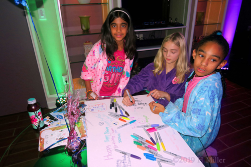 Girls Are Writing On The Spa Birthday Cards With Colorful Pens