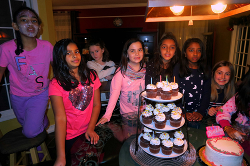 Girls Are Posing With The Cupcakes And Birthday Cake With Big Smiles At The Spa Birthday Party