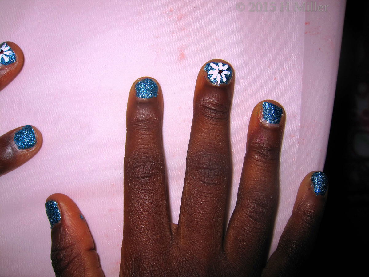 Blue Metallic Nail Polish With White Flower Nail Art.