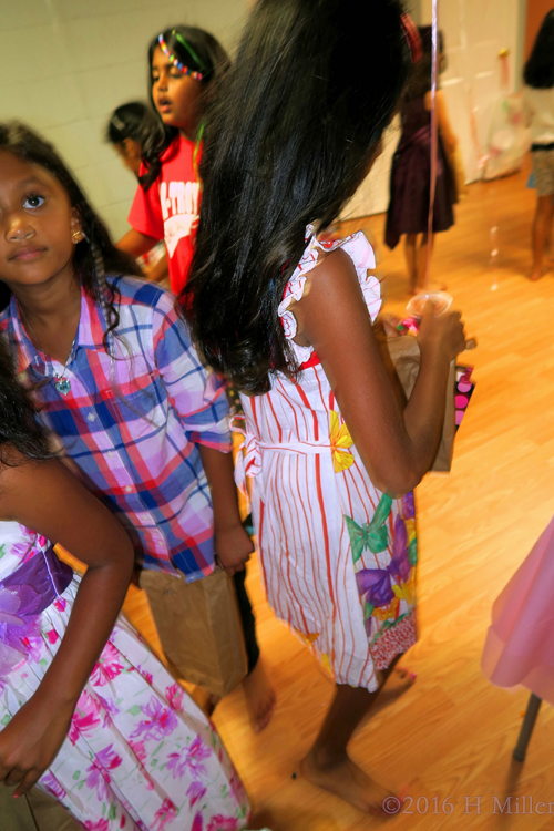 Putting Her Homemade Kids Craft In Her Bag To Take Home. 