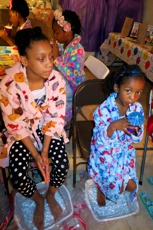 Sips Juice Patiently While Soaking In A Kids Pedicure. Sips Juice Patiently While Soaking In A Kids Pedicure.