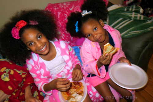 The Birthday Girl And Her Friend Enjoy Their Pizza