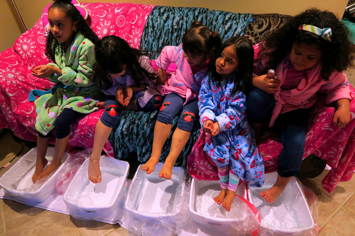 Party Guests In Colorful Robes Enjoying Girls Pedicures 