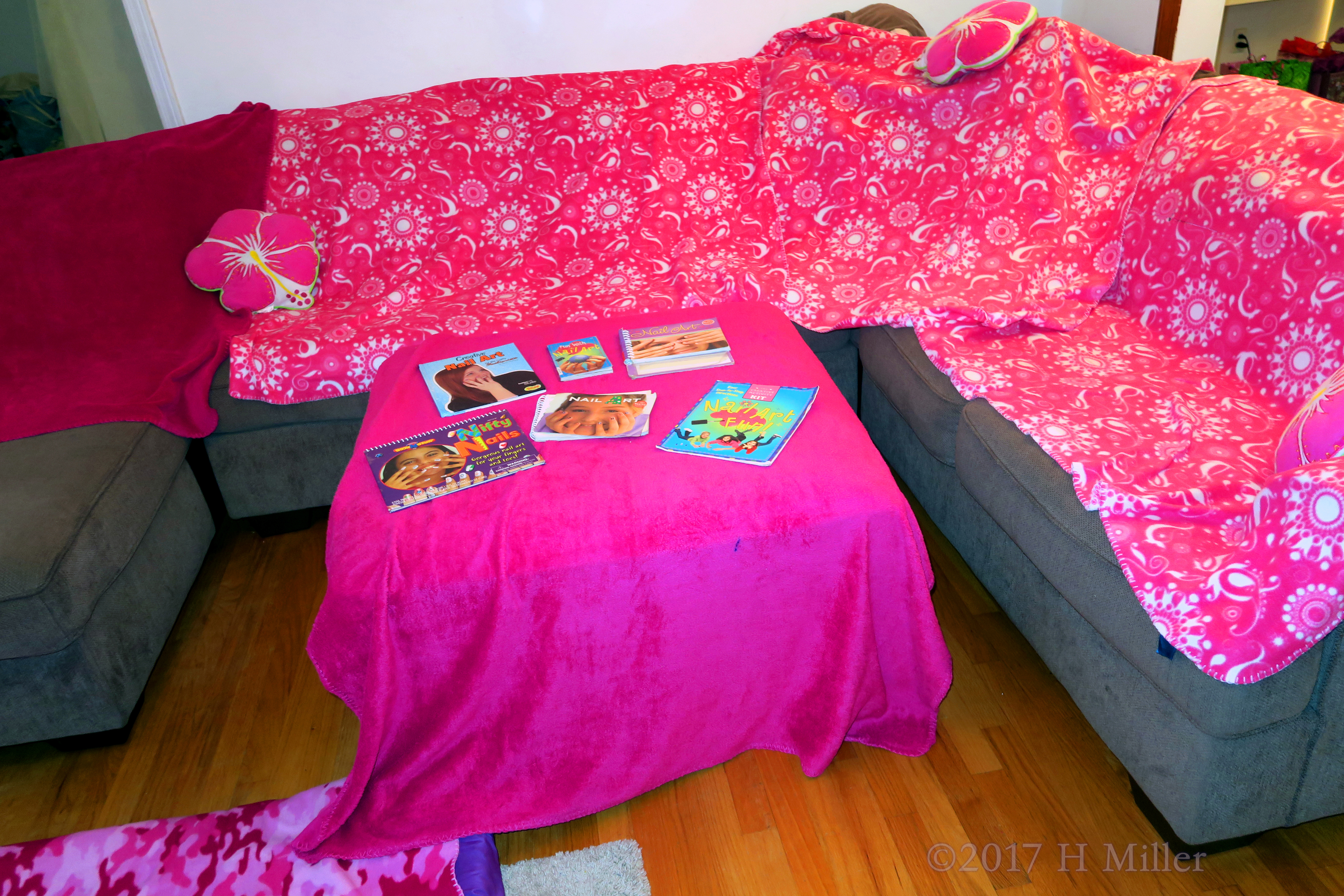 Comfortable Couch With Throws Along With Nail Art Picture Books On The Ottoman. 