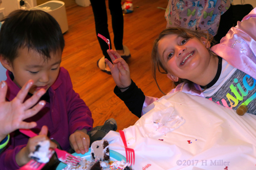 She Poses Silly While He's Still Busy With The Cake. She Poses Silly While He's Still Busy With The Cake.