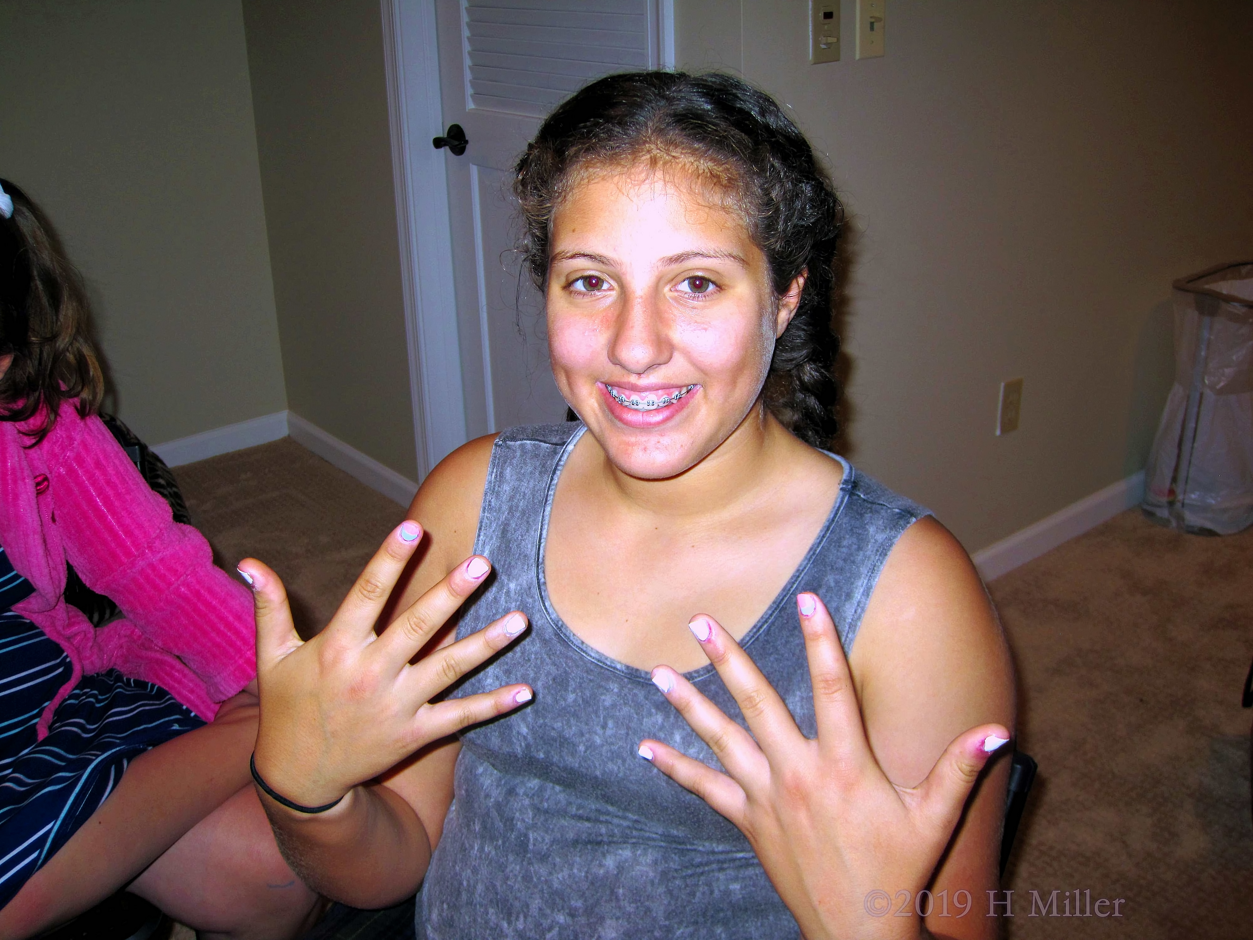 Guest Smiling And Showing Off Pretty White Girls Manicure.