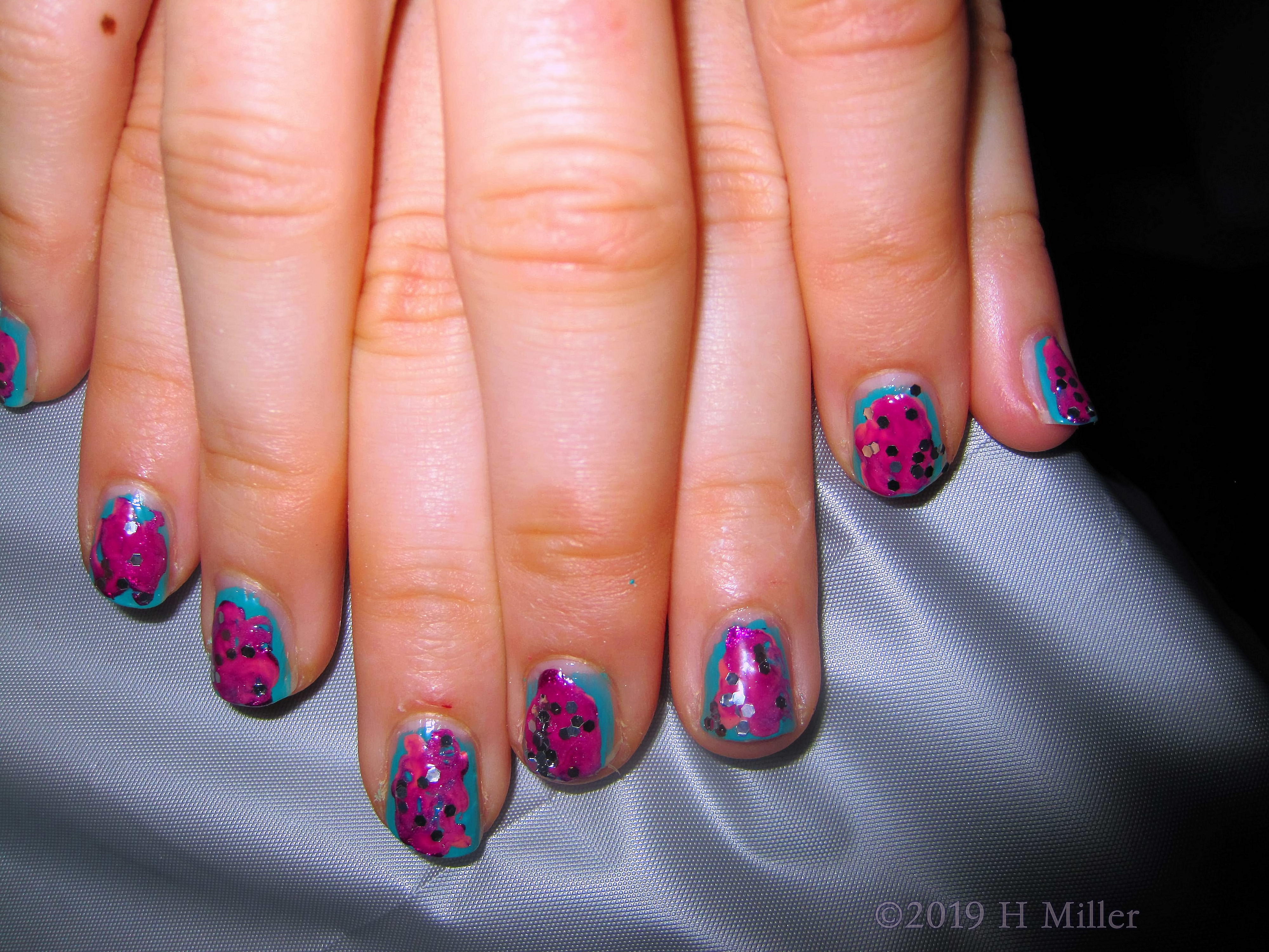 Kids Manicure With Marbling Nail Art With Glitter Overlay.