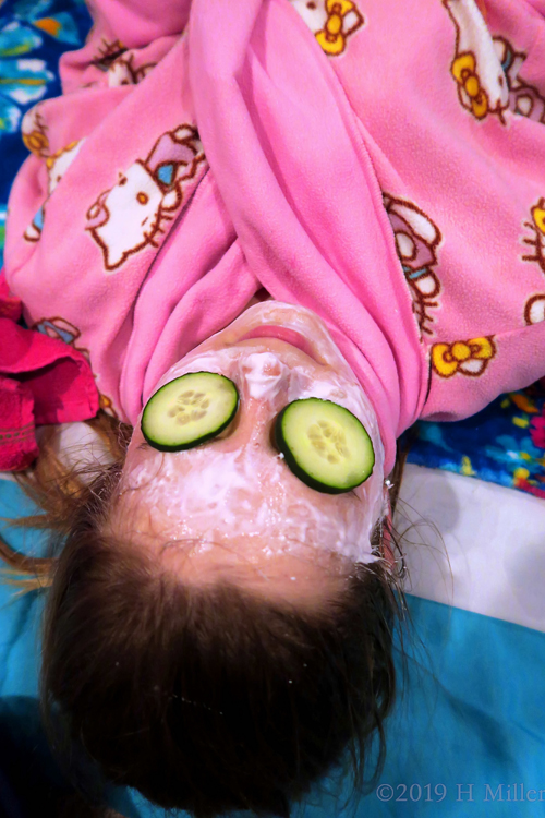 Mackenzie Is Lying On A Spa Mat Having A Kids Facial With Cucumber Slices Over Her Eyes