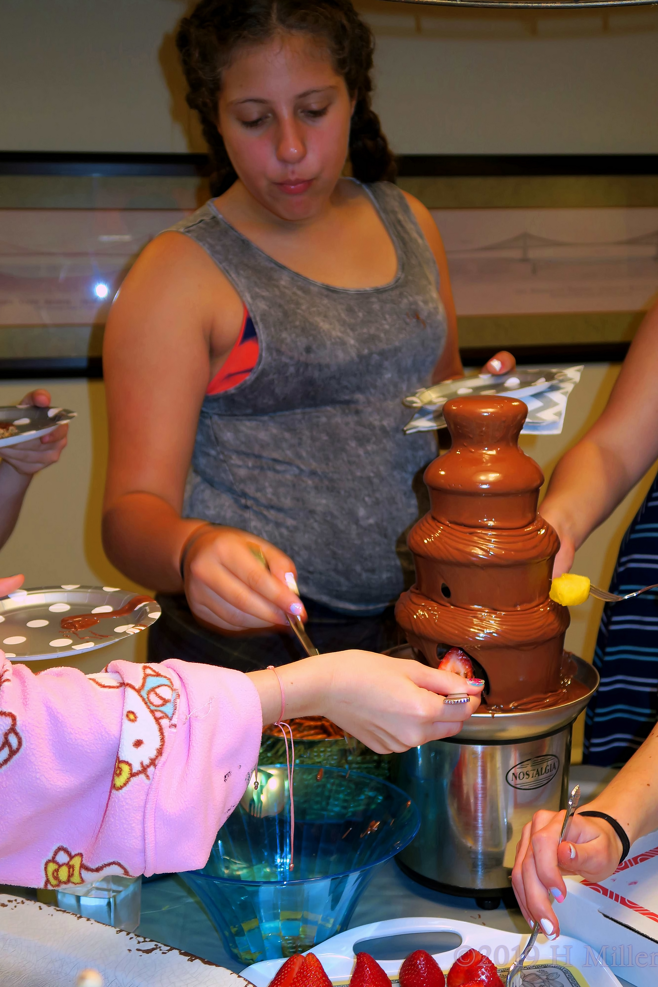 Girls Enjoying Strawberries And Chocolate Fountain Girls Enjoying Strawberries And Chocolate Fountain
