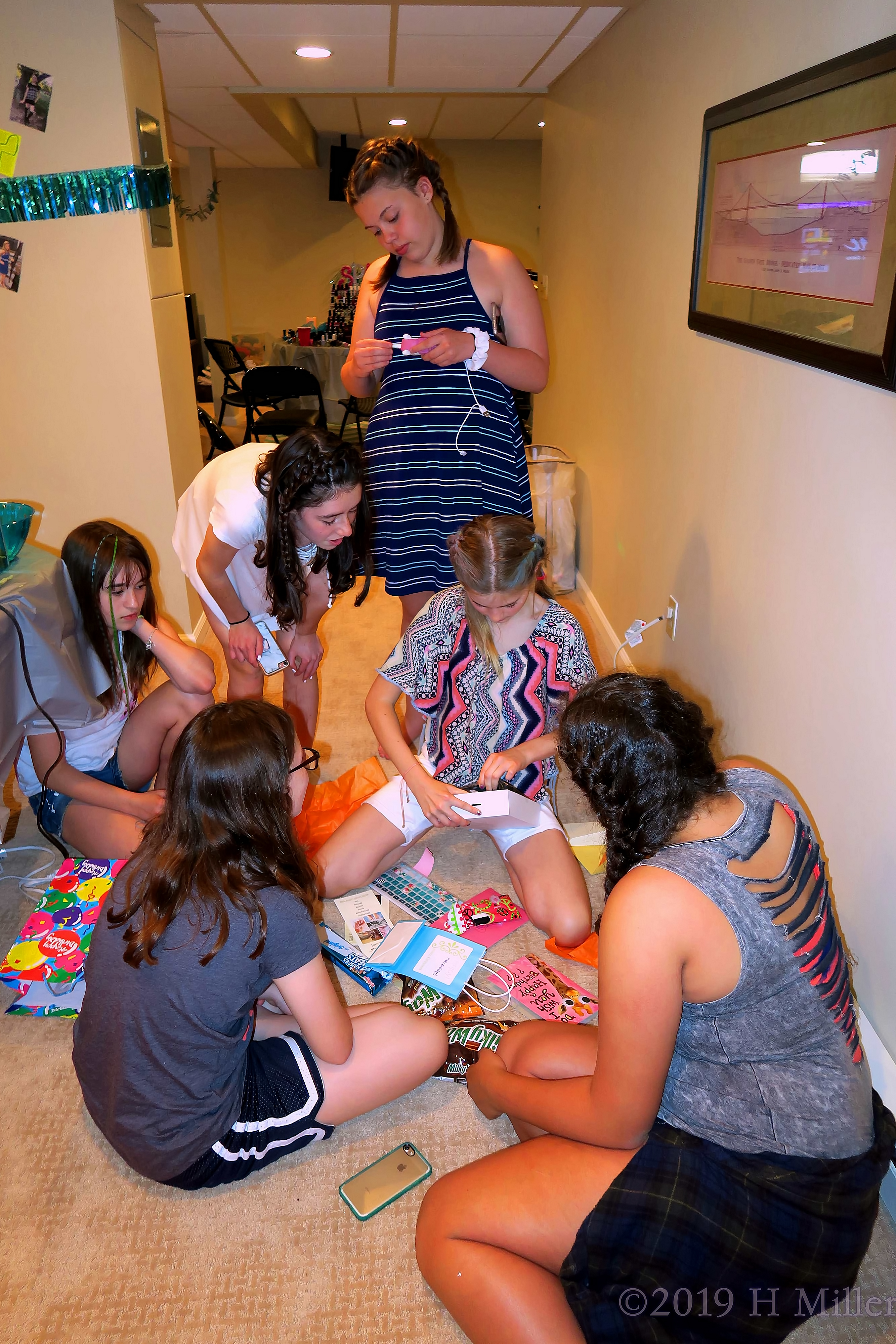 The Birthday Girl Is Surrounded By Friends As She Opens Presents The Birthday Girl Is Surrounded By Friends As She Opens Presents