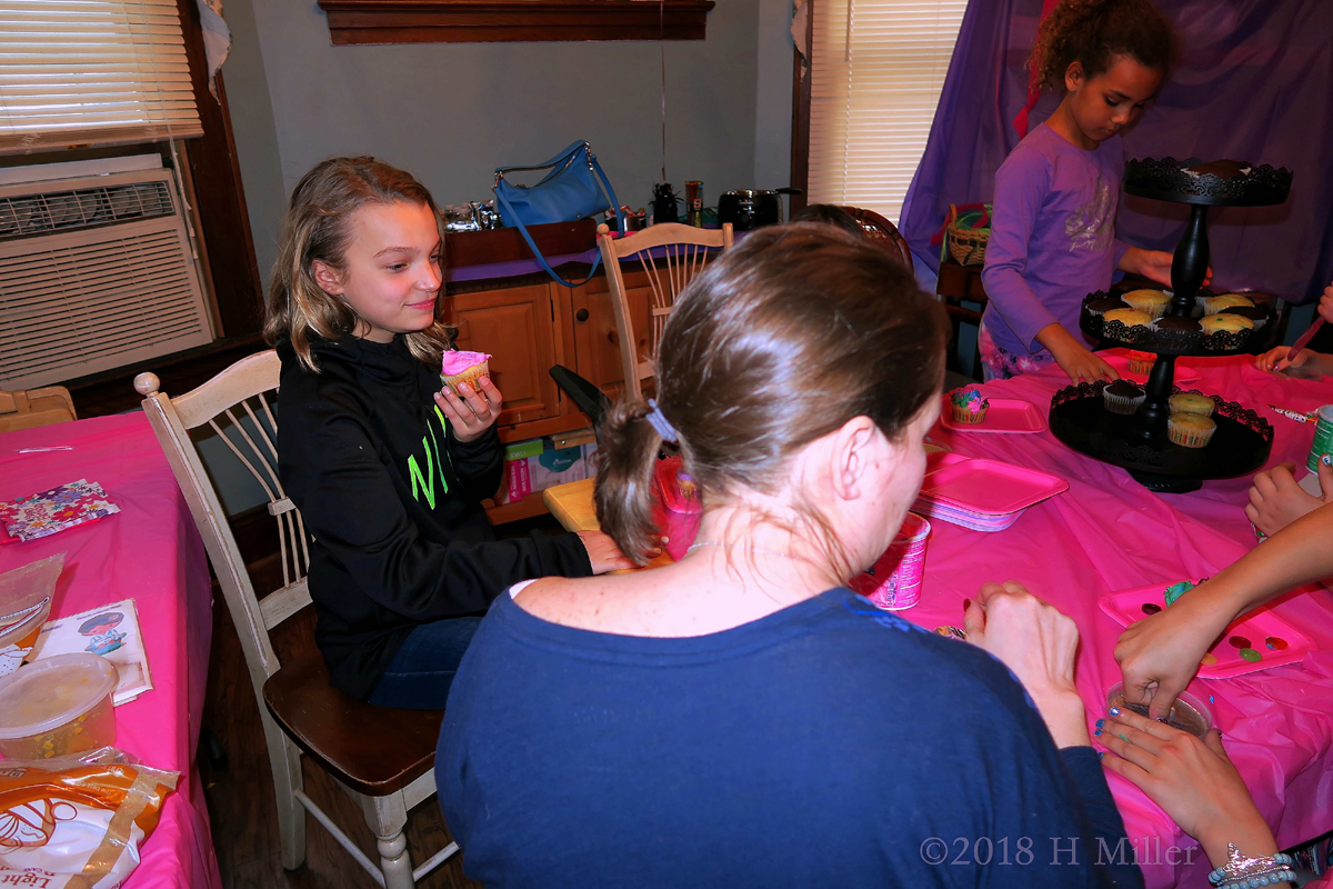 Spa Girl Smiling While Eating A Pink Frosted Cupcake 