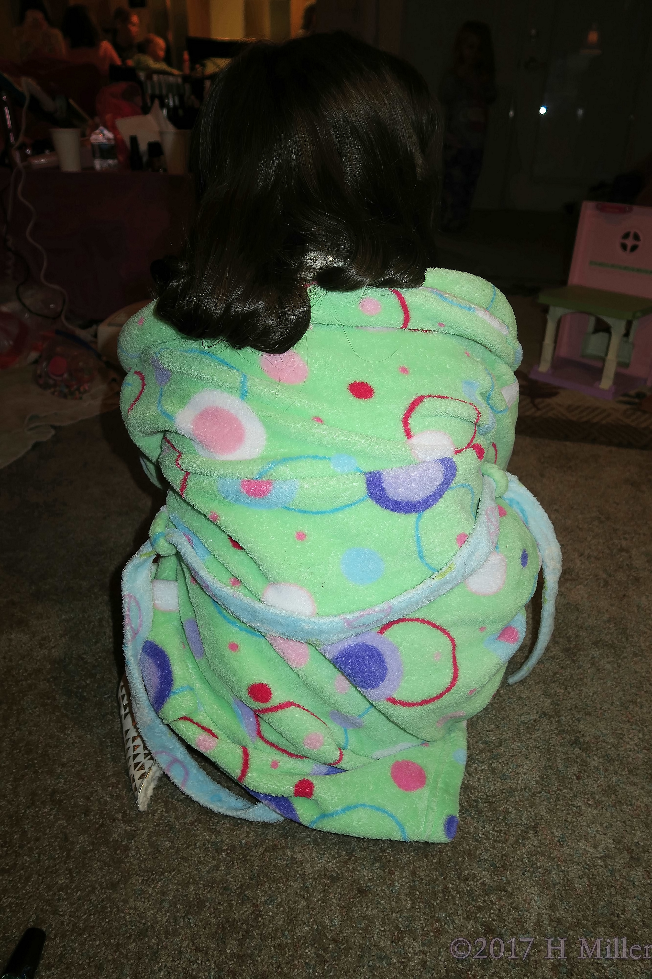 Fluffy Green Spa Robe With Orange And Blue Designs, Showing Off Her Curled Kids Hairstyle. Fluffy Green Spa Robe With Orange And Blue Designs, Showing Off Her Curled Kids Hairstyle.