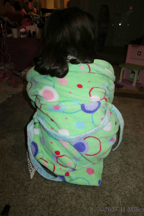 Fluffy Green Spa Robe With Orange And Blue Designs, Showing Off Her Curled Kids Hairstyle.