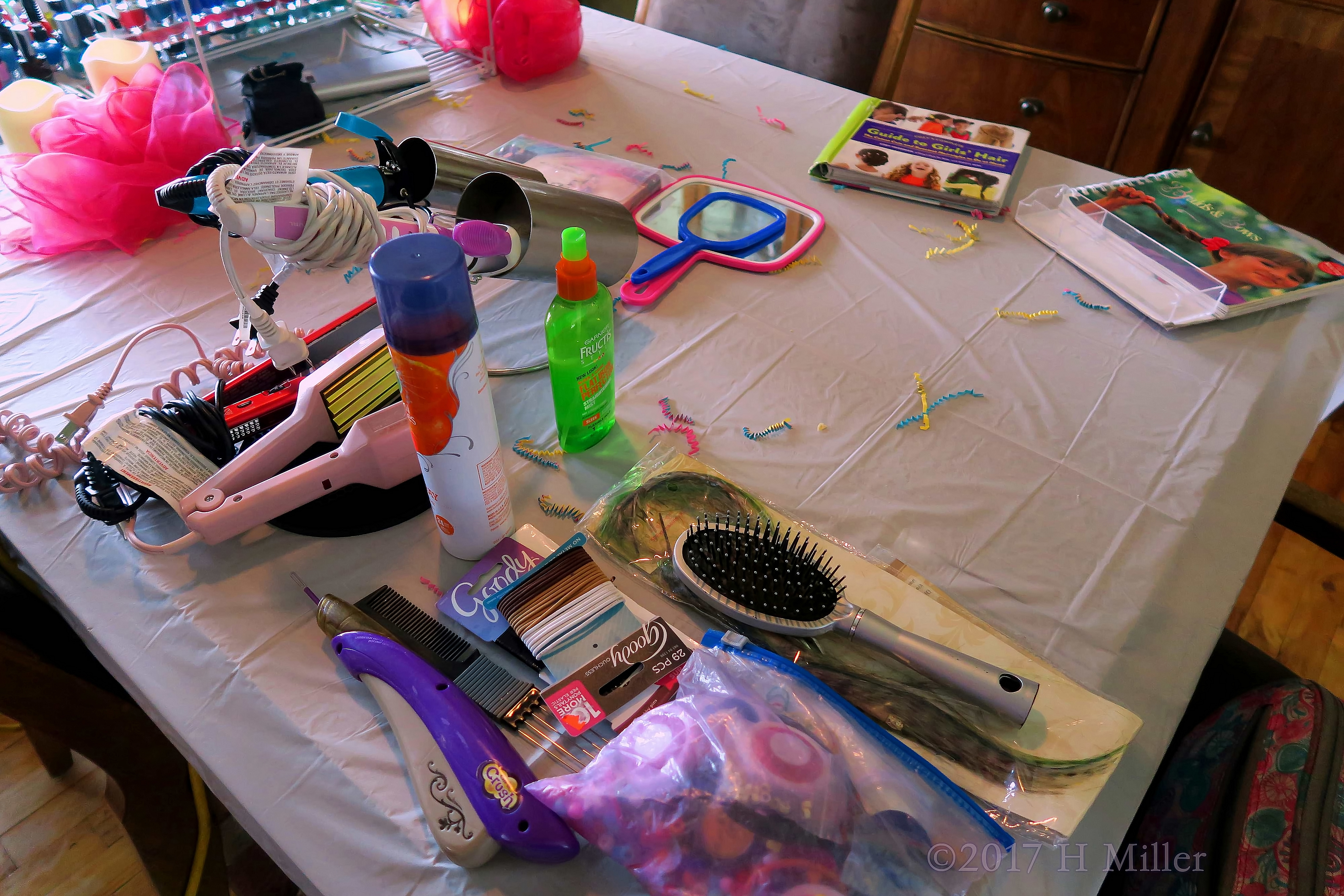 A Table Full Of Of Hairstyling Products With Books For Ideas!