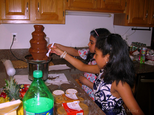 Kids Are Enjoying Dipping And Eating Chocolate Fondue