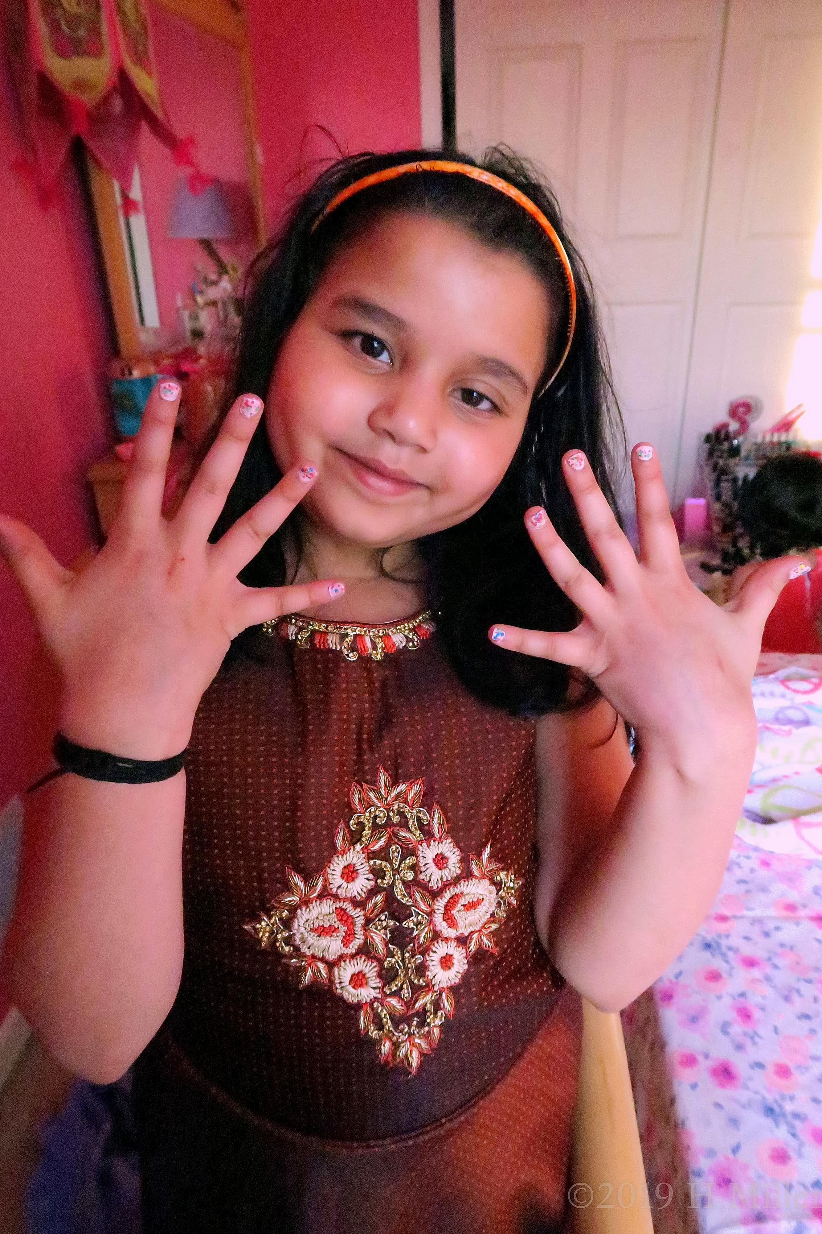 Showing Her New Rainbow Glittery Kids Manicure With A Smile 