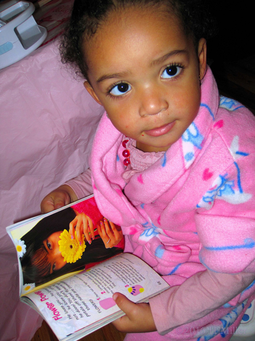 Looking At Nail Art Books To Get Ideas For Her Favorite Nail Design.