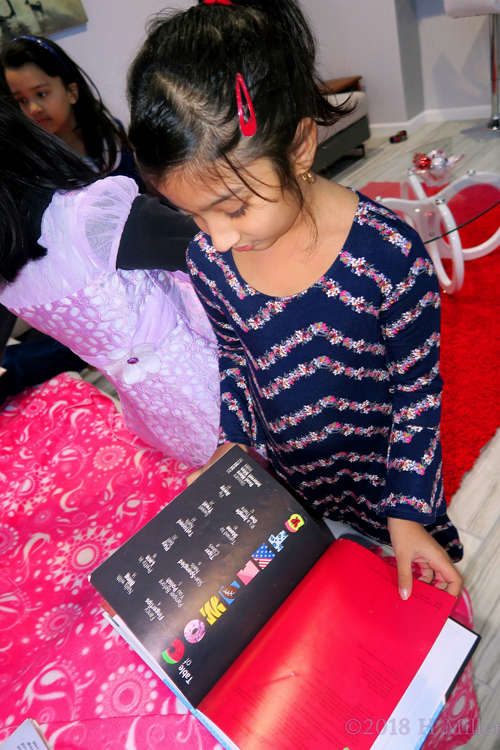 Party Guest Checking Out Nail Art Book For Ideas For Her Mini Mani