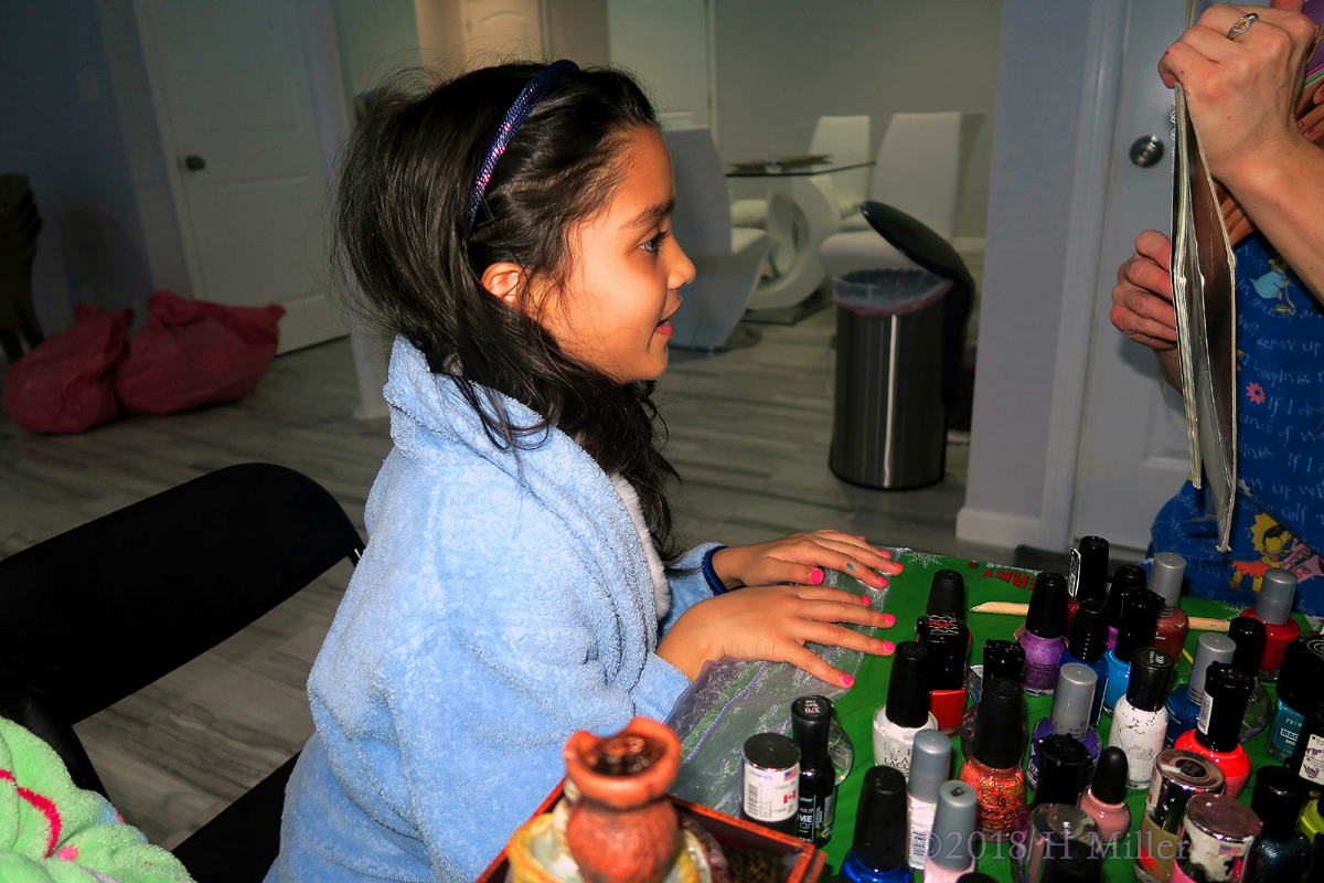 Party Guest In Blue Looking At Her Pink Nail Art Design