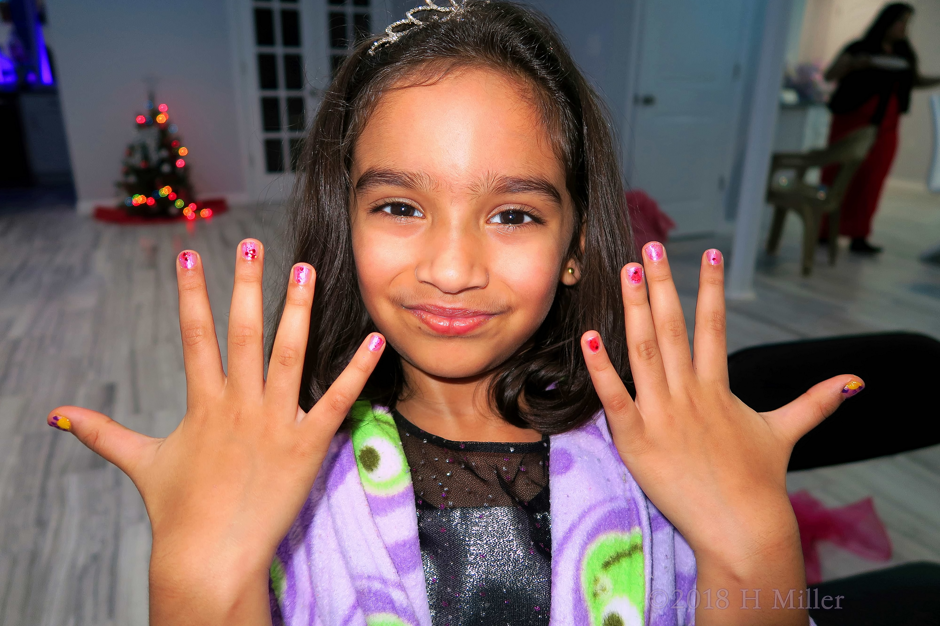 Showing Off Her Pink Kids Manicure With Glitter Overlay 