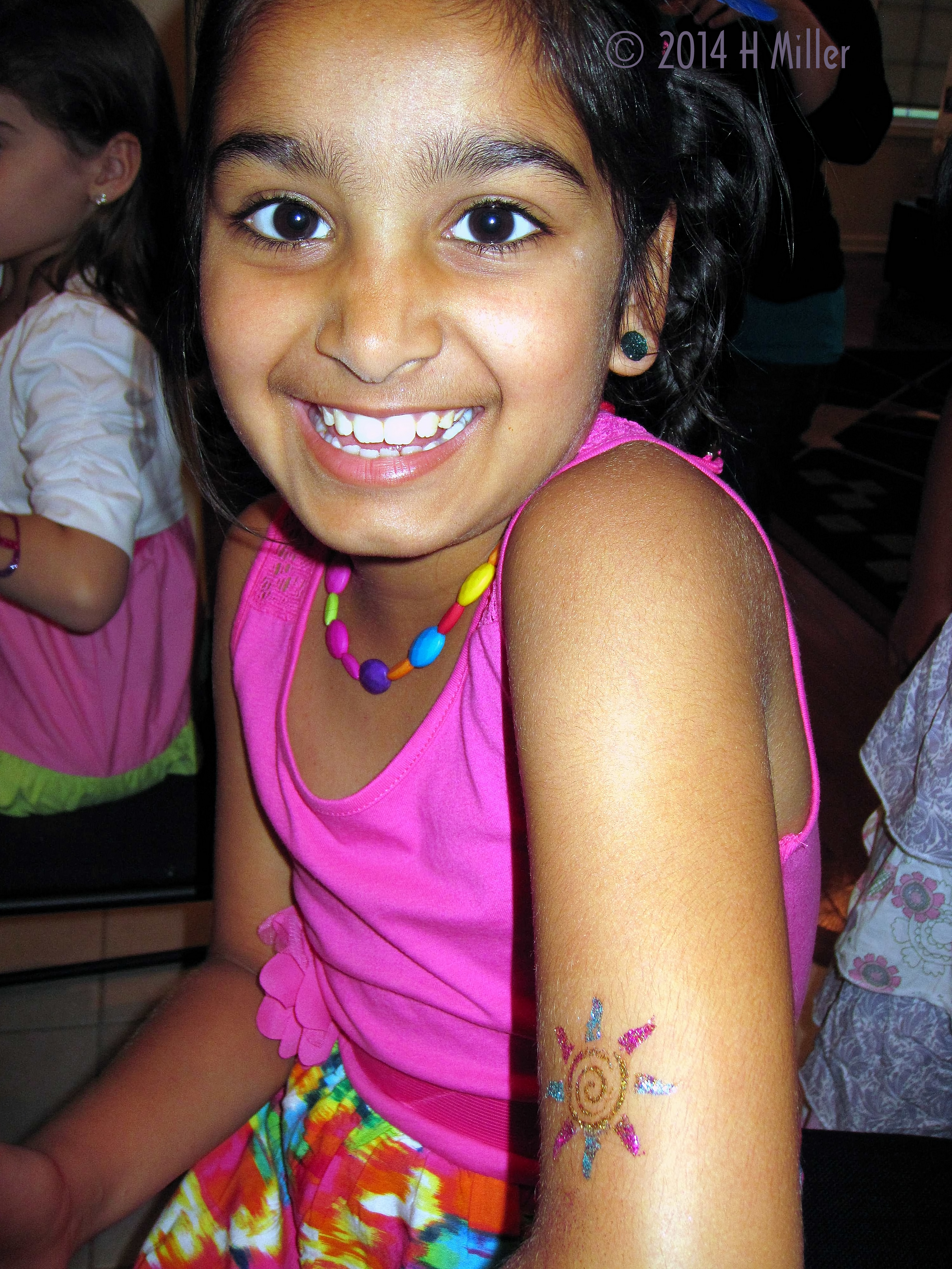 Body Glitter Art Spiraling Sun Done In Colors Matching Outfit At Navya's Girls Spa Party. 