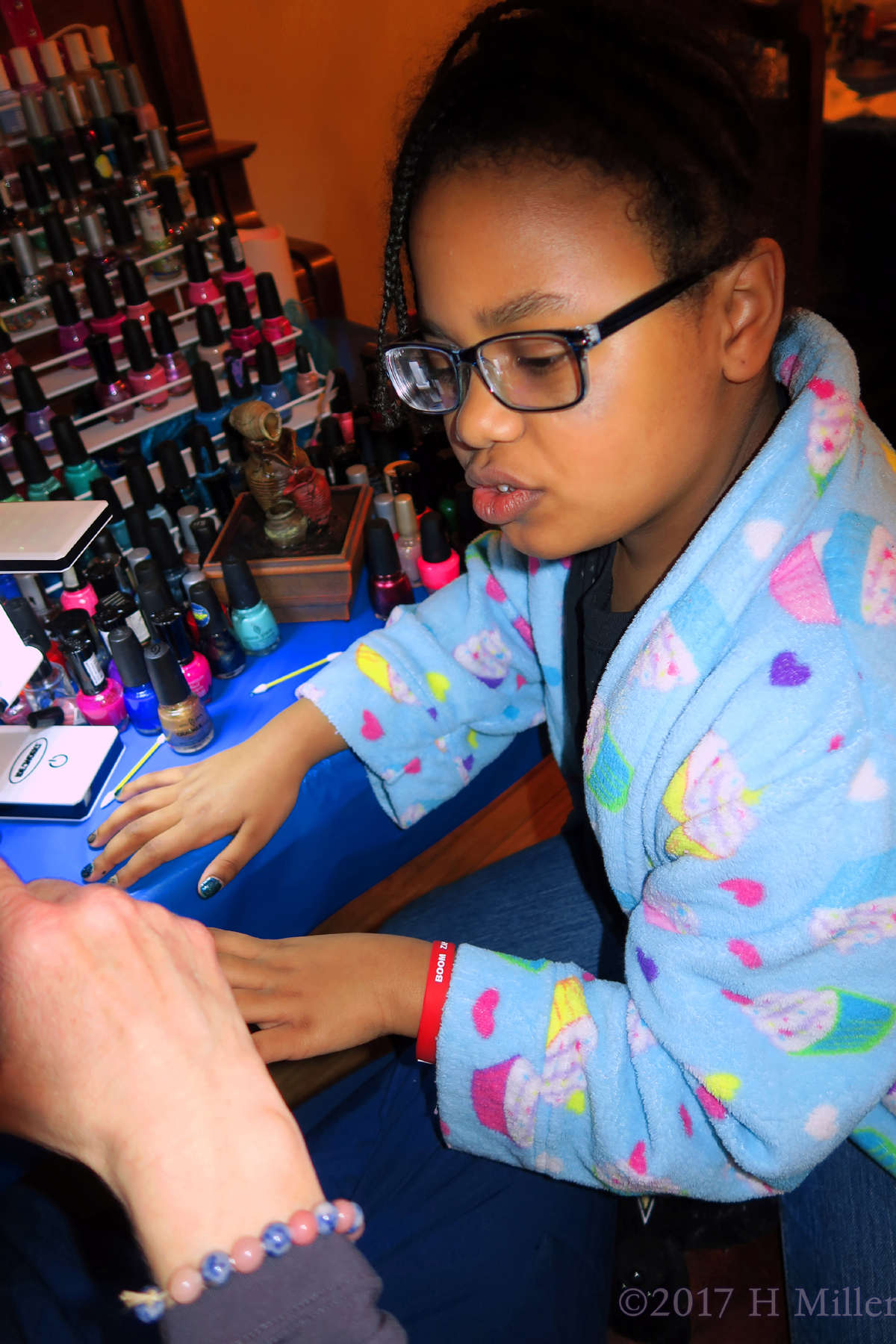 Focusing Intently On Her Kids Manicure. 