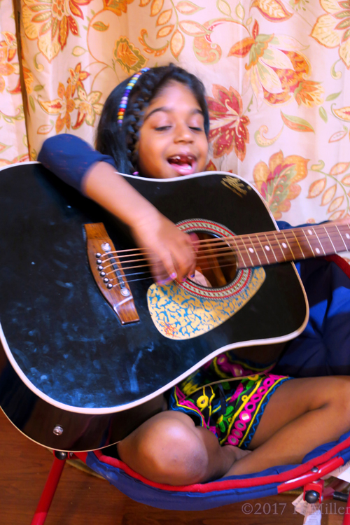 Singing And Playing Guitar At Her Birthday Party.