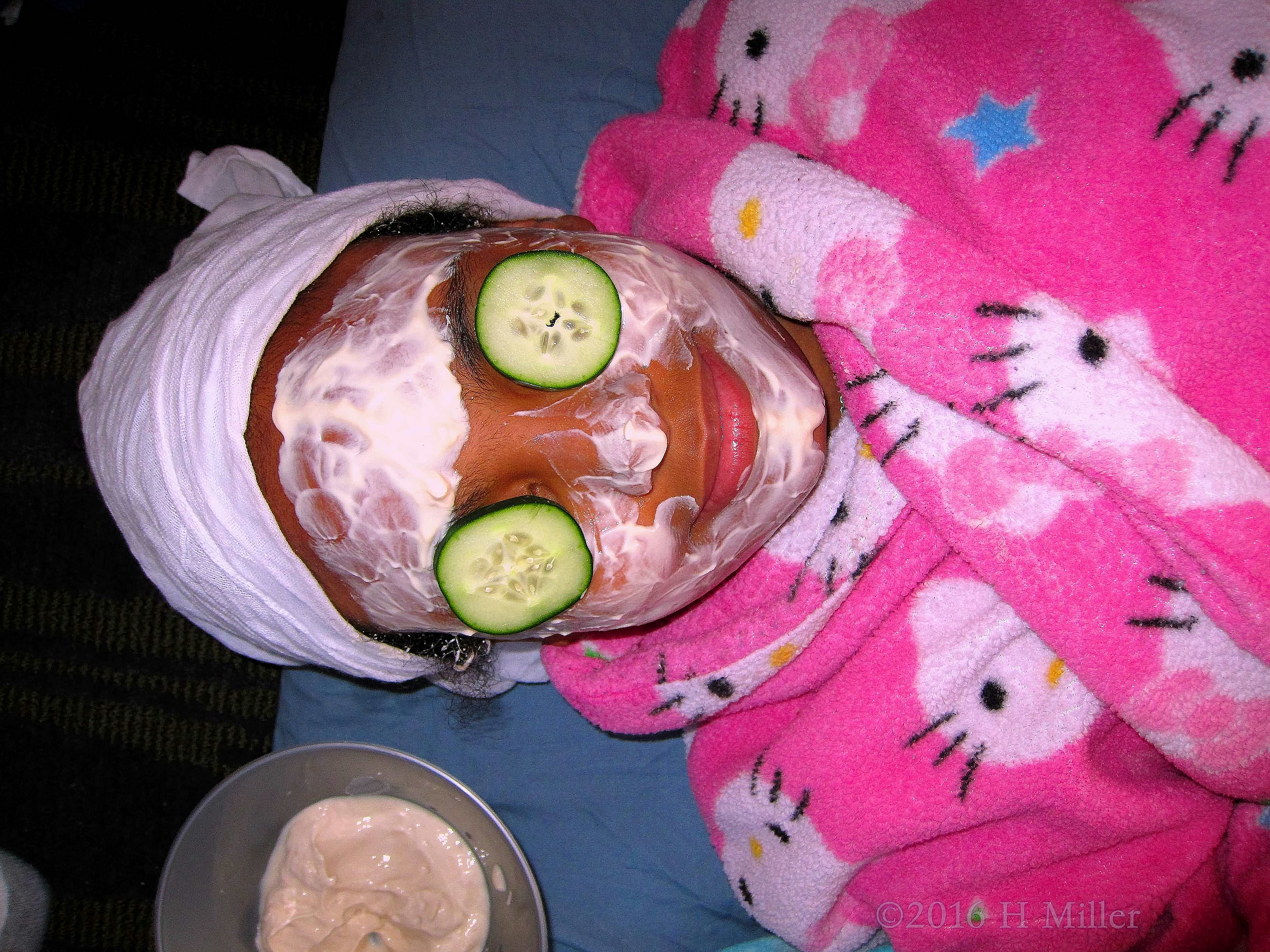 Close View Of Kids Facial With Cukes On The Eyes. 