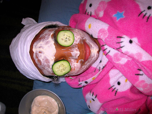 Close View Of Kids Facial With Cukes On The Eyes.