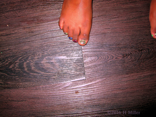 Girl's Pedicure In Rainbow Metallic Colors.