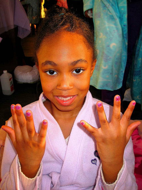 Smiling While Showing Her Pretty Pink And Glitter Mini Manicure.