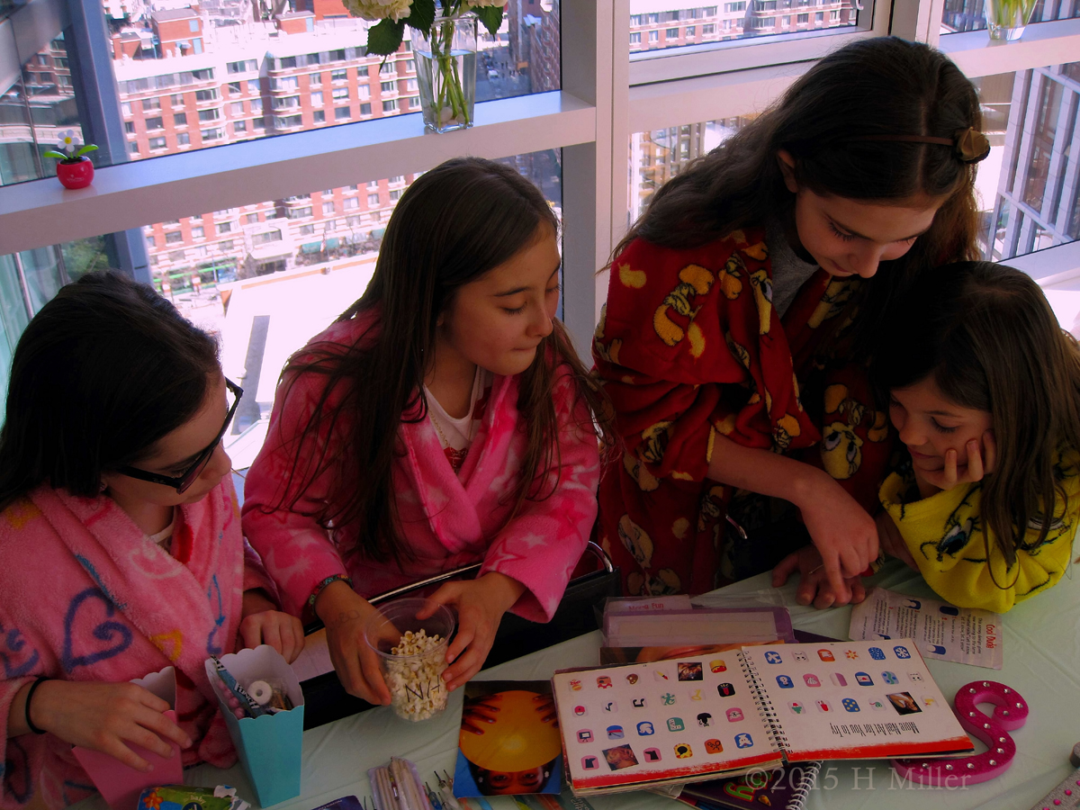 The Girls Checking Out The Various Nail Art Design Books. 