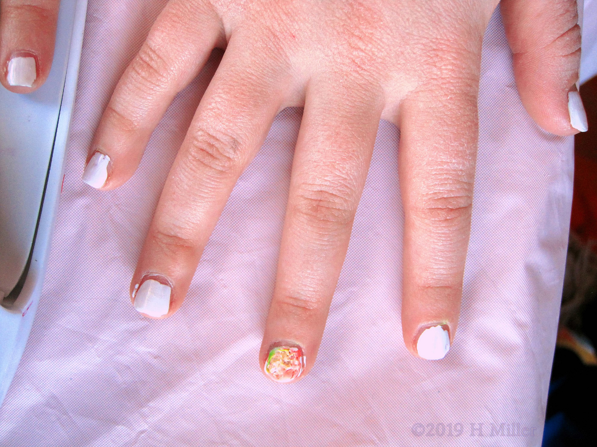 A Very Pretty White Kids Manicure With A Green, Yellow, And Orange Marbled Nail Design! 